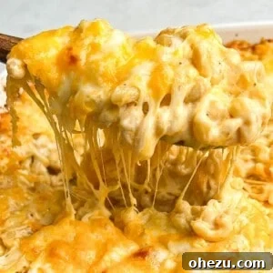 macaroni and cheese being lifted out of a pan with a spoon