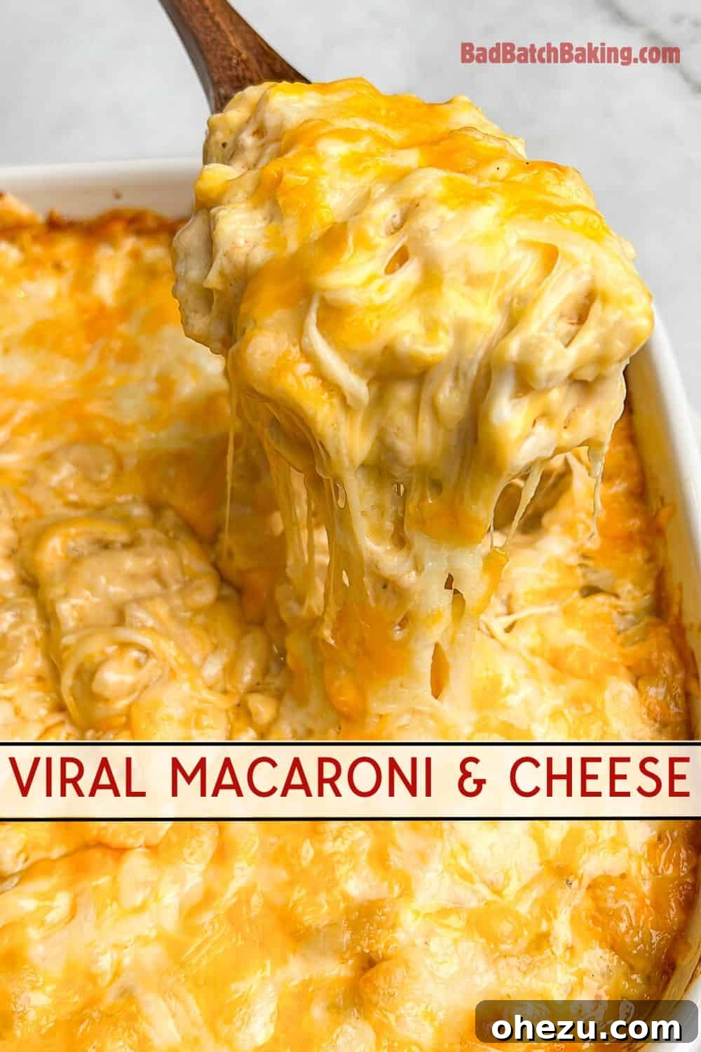 A top-down view of macaroni and cheese in a pan, with a serving spoon taking a portion, emphasizing the creamy texture.