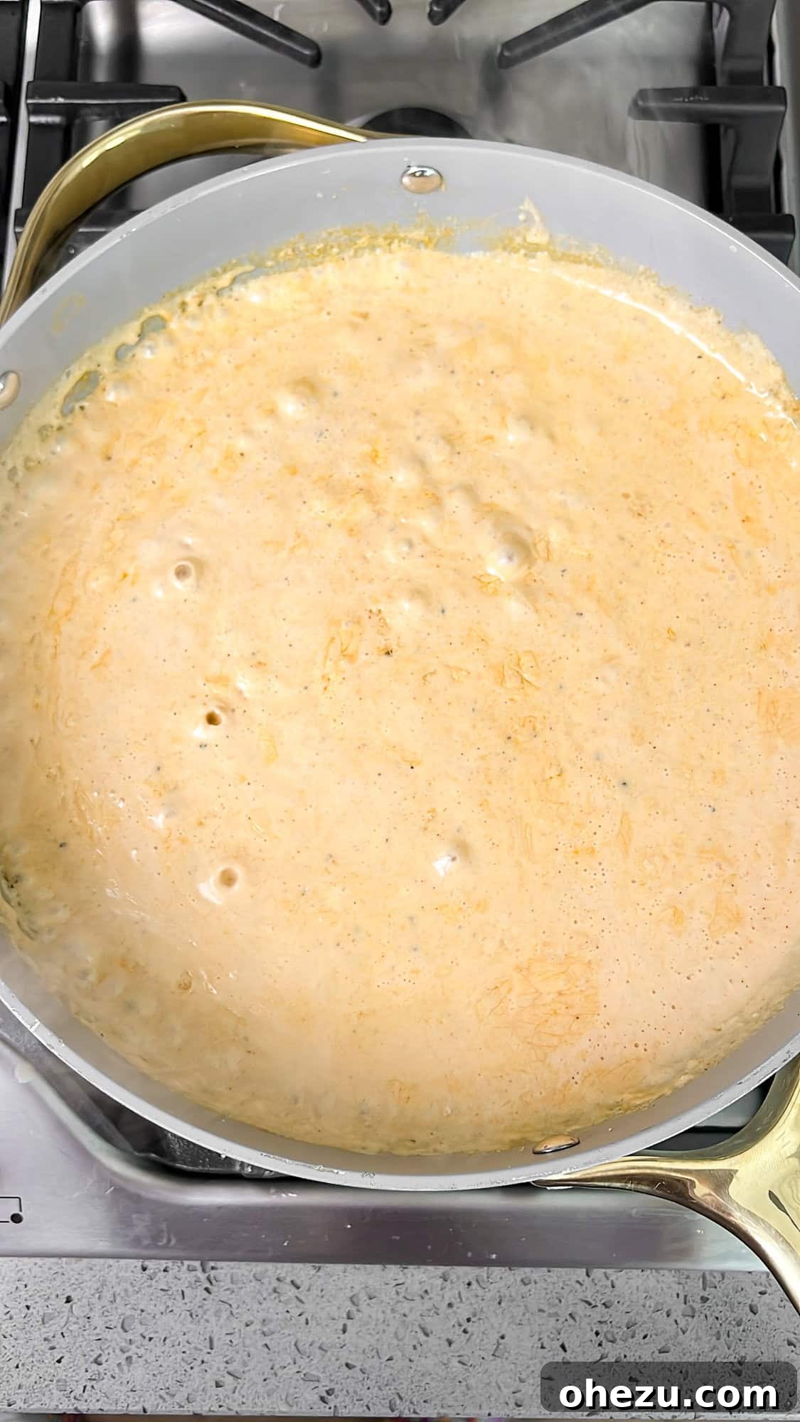 The creamy sauce brought to a gentle simmer in a pan, thickening beautifully.