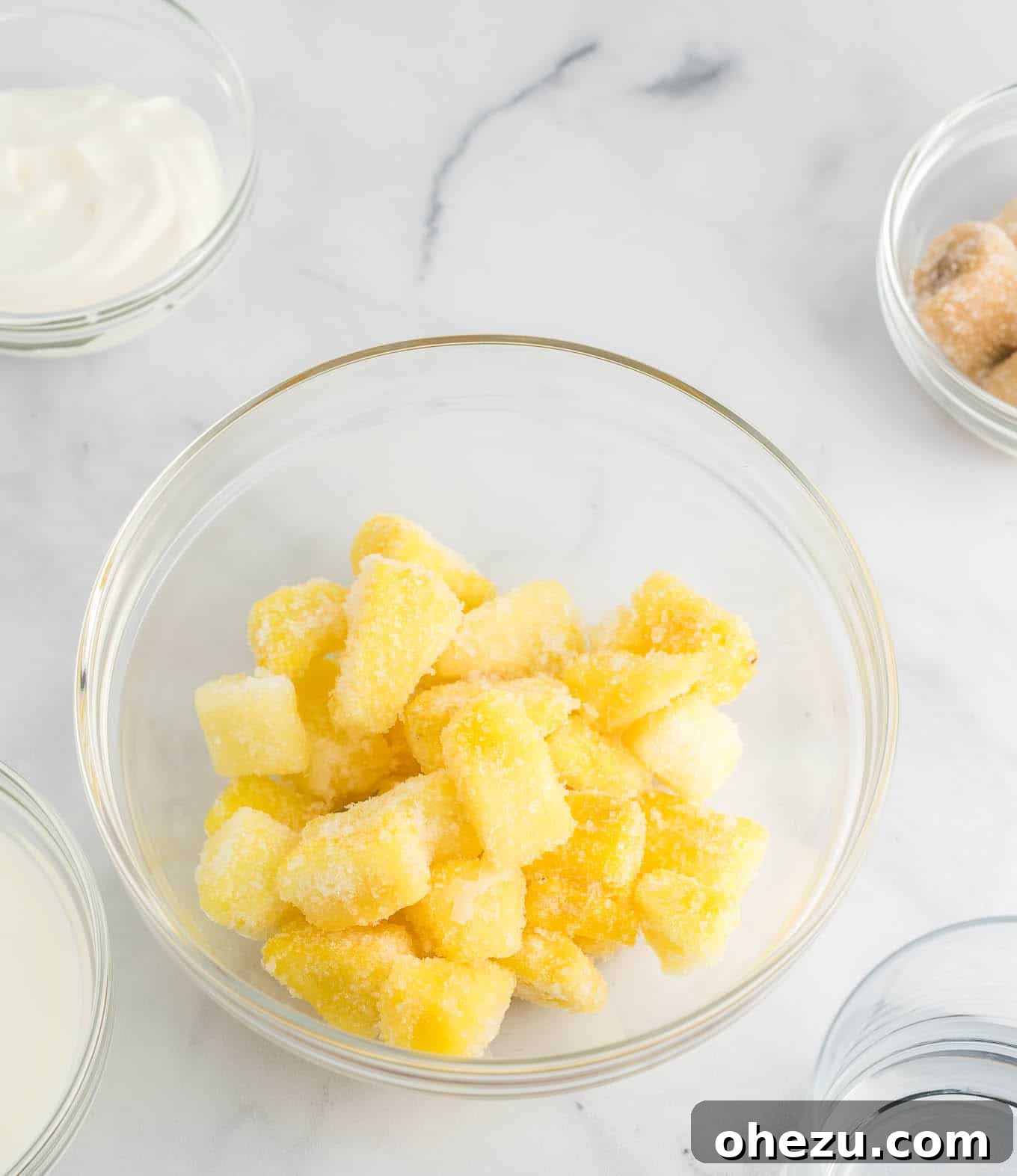 Golden Pineapple Chill 4 A clear glass bowl filled with perfectly cut frozen pineapple chunks, ready for blending.