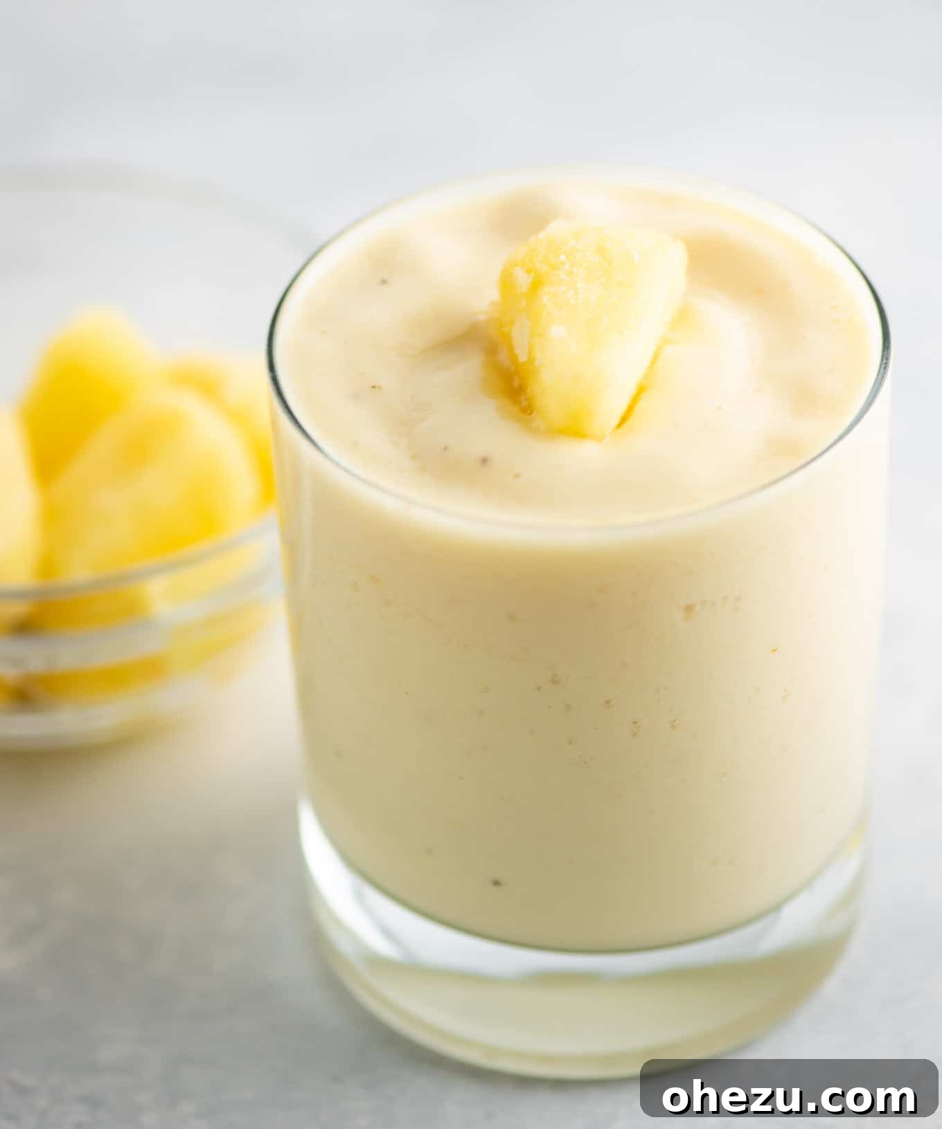 Golden Pineapple Chill 7 A tall glass filled with the vibrant frosty pineapple smoothie, ready to be enjoyed, with a soft background.