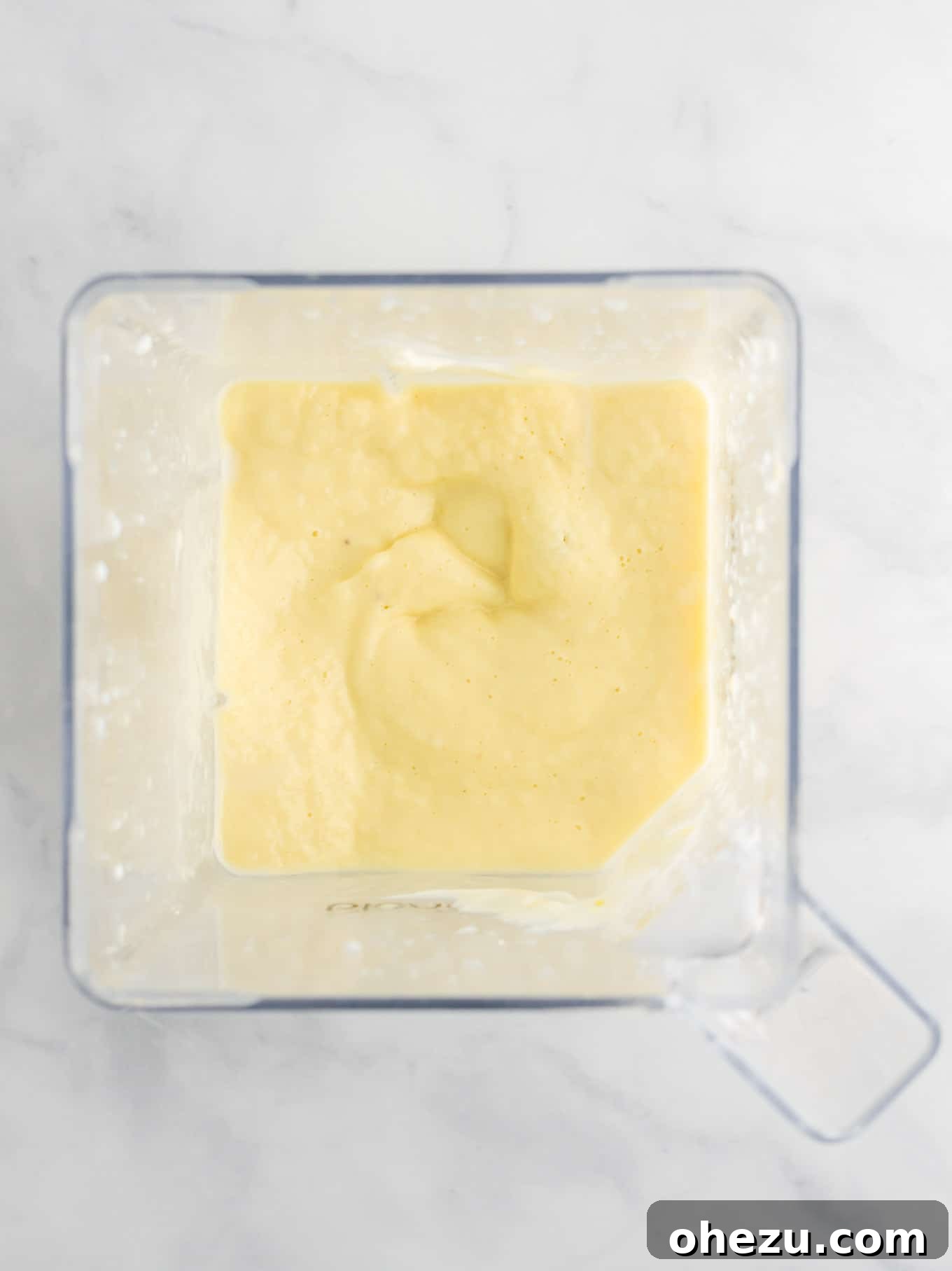 Golden Pineapple Chill 8 An overhead shot of a blender jar filled with the vibrant yellow smoothie mixture, mid-blend, showcasing the creamy texture.
