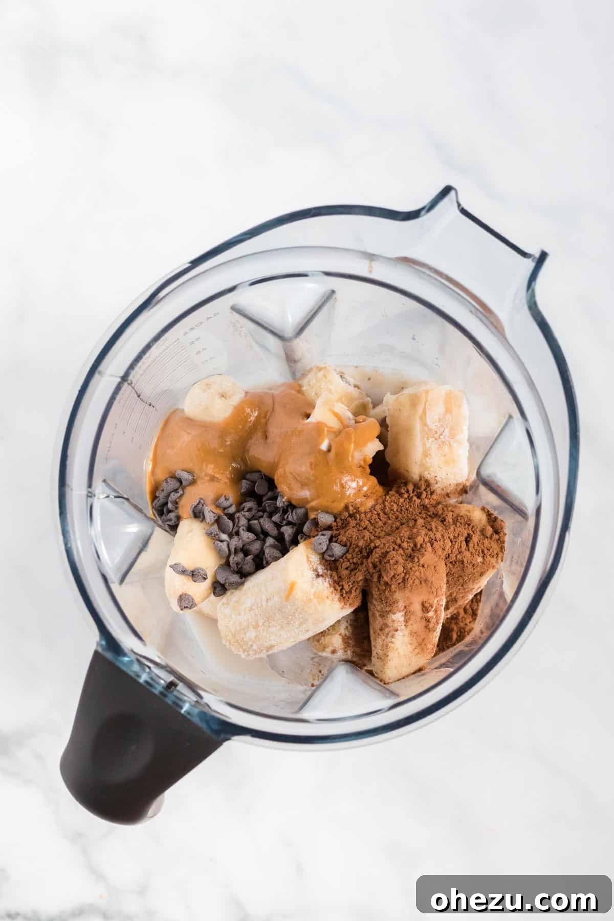 All ingredients for the smoothie placed inside a blender jar, ready for blending.