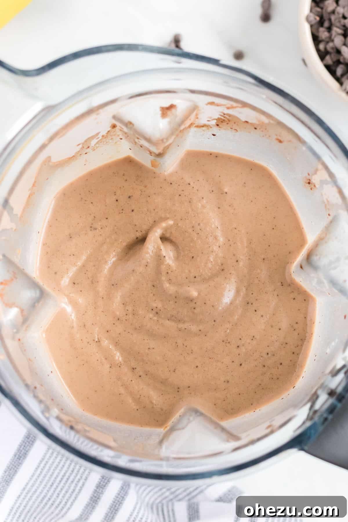Overhead view of a blender with the chocolate peanut butter banana smoothie blending inside.
