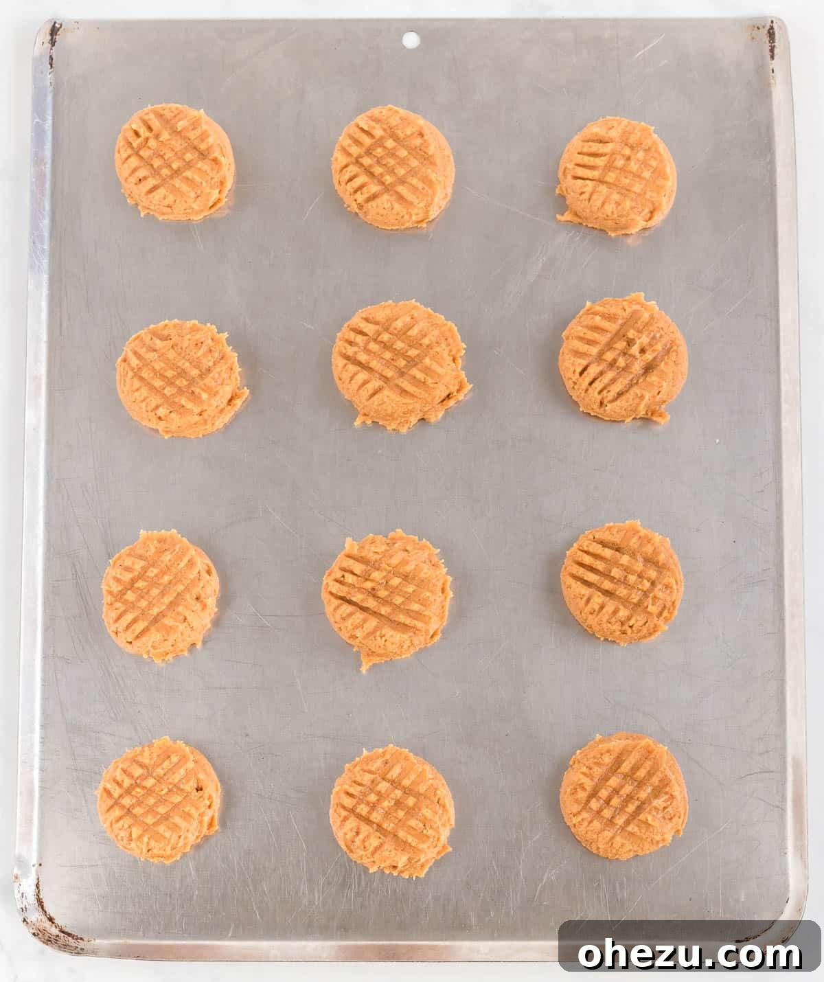Gluten-Free Peanut Butter Cookies 7 Cookie dough balls pressed with a fork to create the classic crisscross pattern