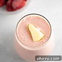 strawberry pineapple smoothie recipe with a piece of frozen pineapple on top