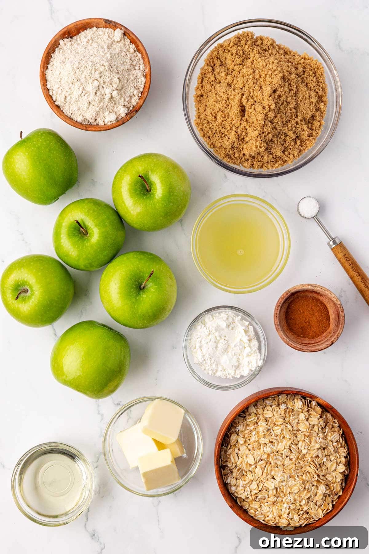 Heavenly Gluten-Free Apple Crumble 4 A selection of fresh ingredients laid out, including Granny Smith apples, brown sugar, cinnamon, and oats, ready for making gluten-free apple crisp.