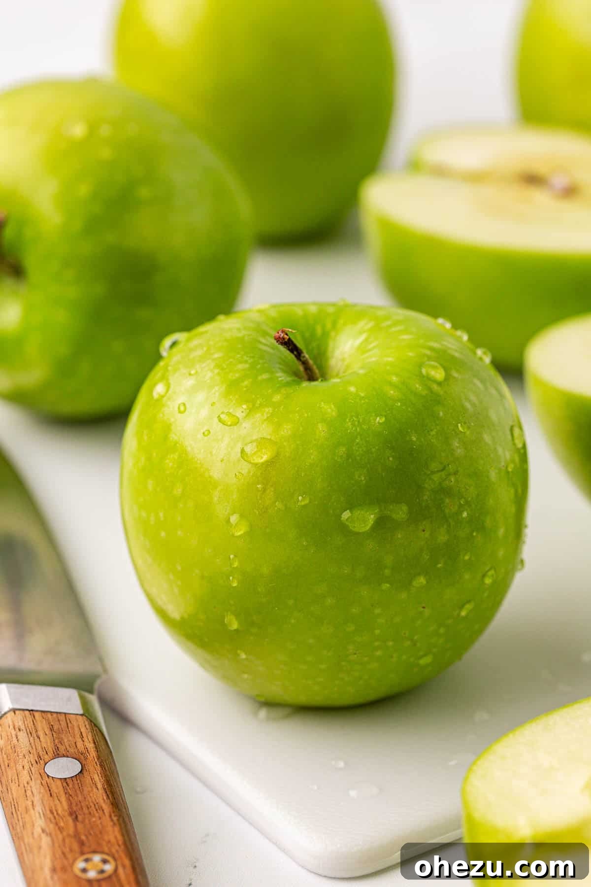 Heavenly Gluten-Free Apple Crumble 5 A single crisp green Granny Smith apple resting on a wooden cutting board, ready to be prepared for baking.
