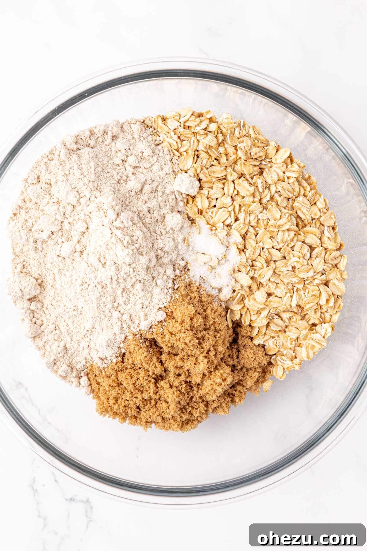 Heavenly Gluten-Free Apple Crumble 9 Dry ingredients for the gluten-free crisp topping, including brown sugar, oat flour, and rolled oats, mixed in a bowl.
