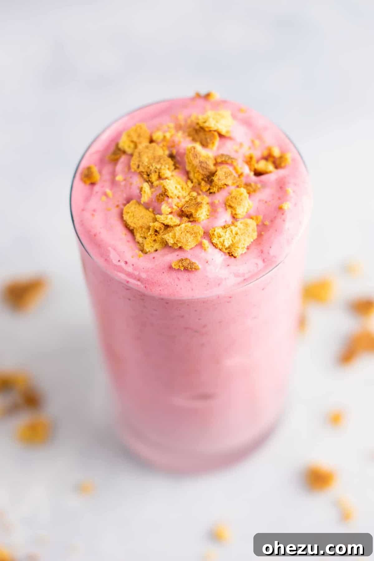 Mastering Homemade Smoothies 13 a delightful strawberry cheesecake smoothie served in a clear glass, topped with a sprinkle of crushed graham crackers for an authentic dessert feel