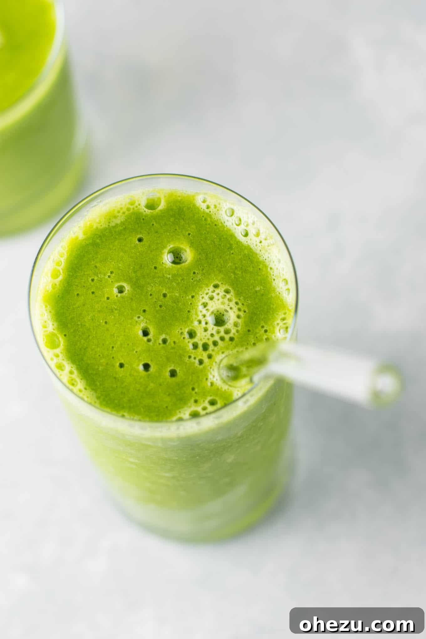 Mastering Homemade Smoothies 3 overhead view of a vibrant green smoothie in a glass with a straw, surrounded by fresh greens