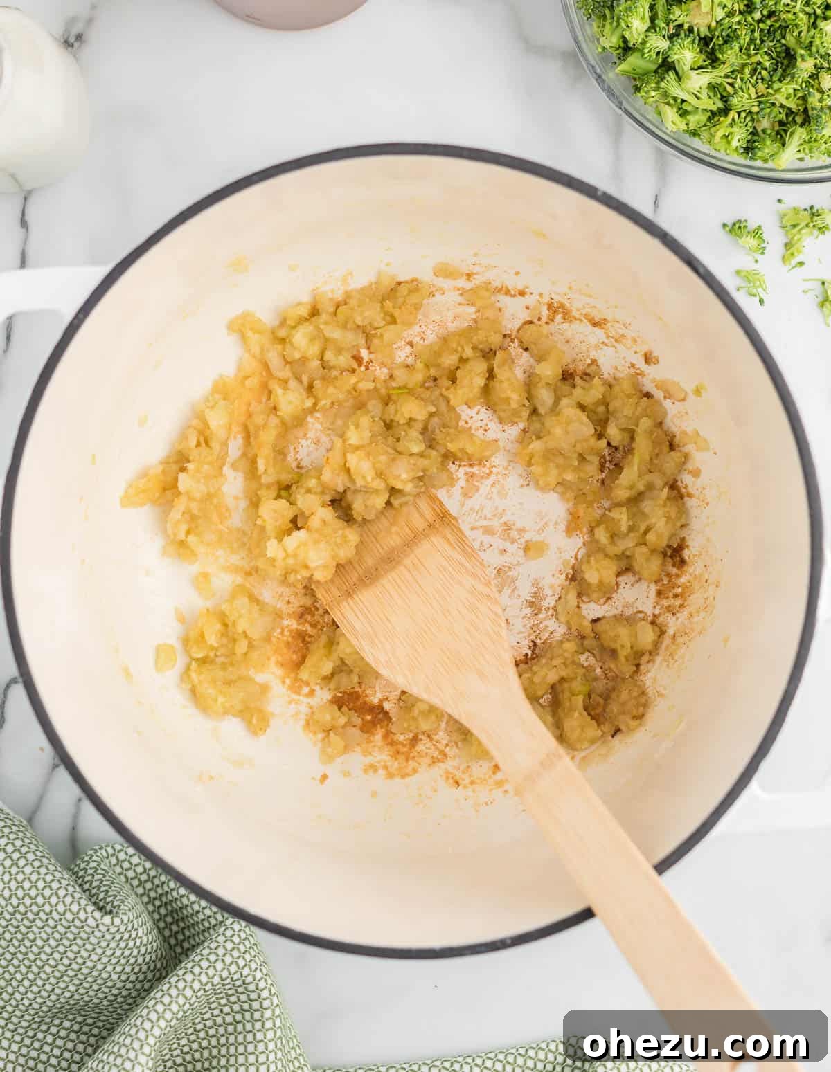 Minced garlic and softened, slightly caramelized onions simmering together in a Dutch oven, releasing their aromas.
