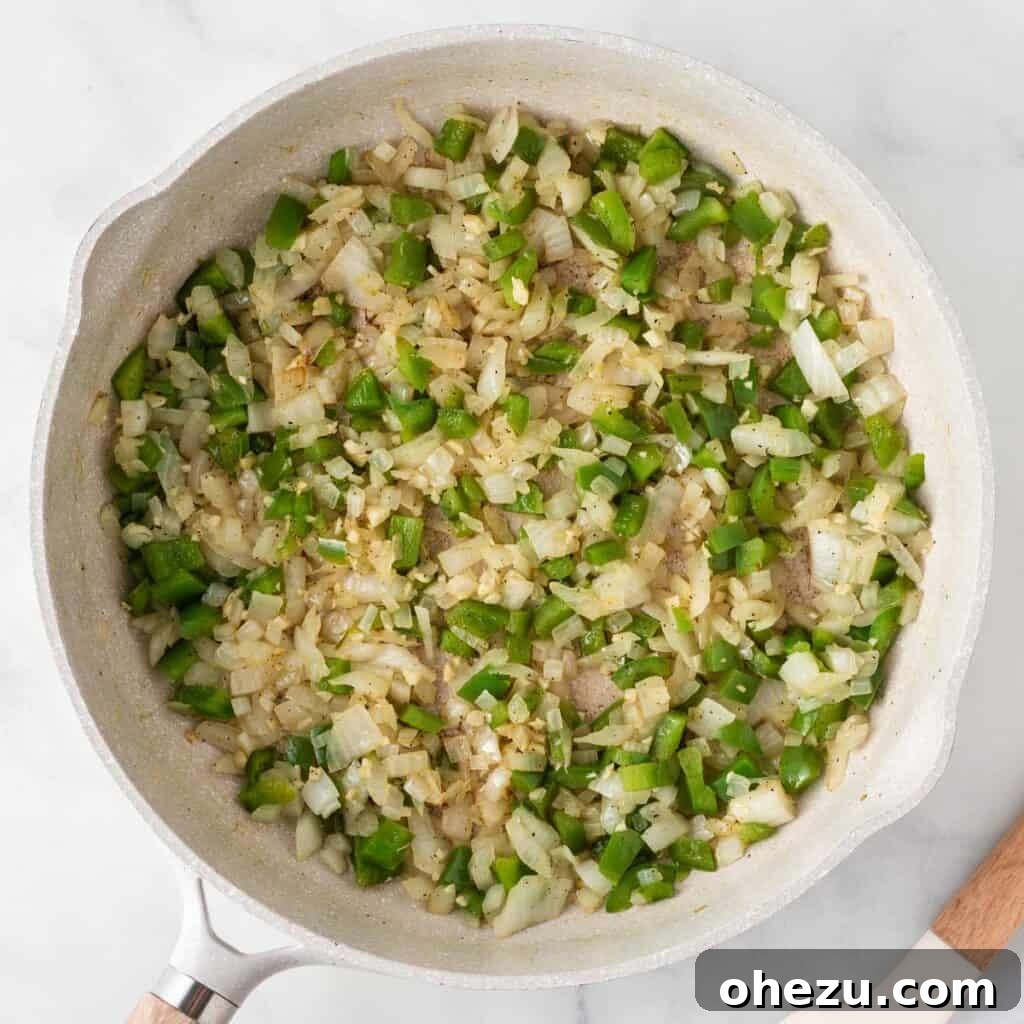 Cooked bell pepper, onion, and garlic, softened and fragrant, resting in a skillet after sautéing.