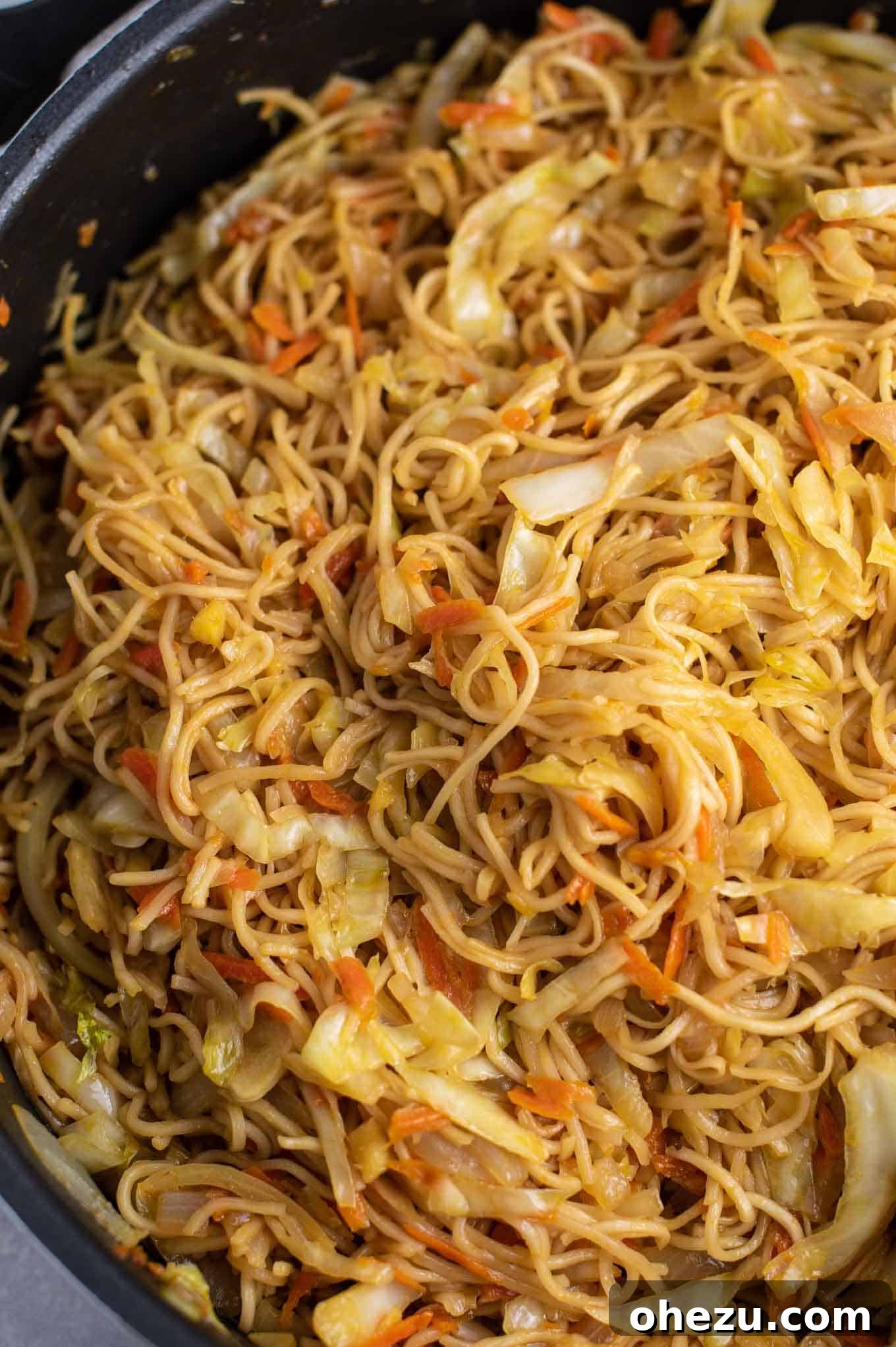 Another enticing view of the stir-fried cabbage and noodles, glistening with sauce in the skillet.