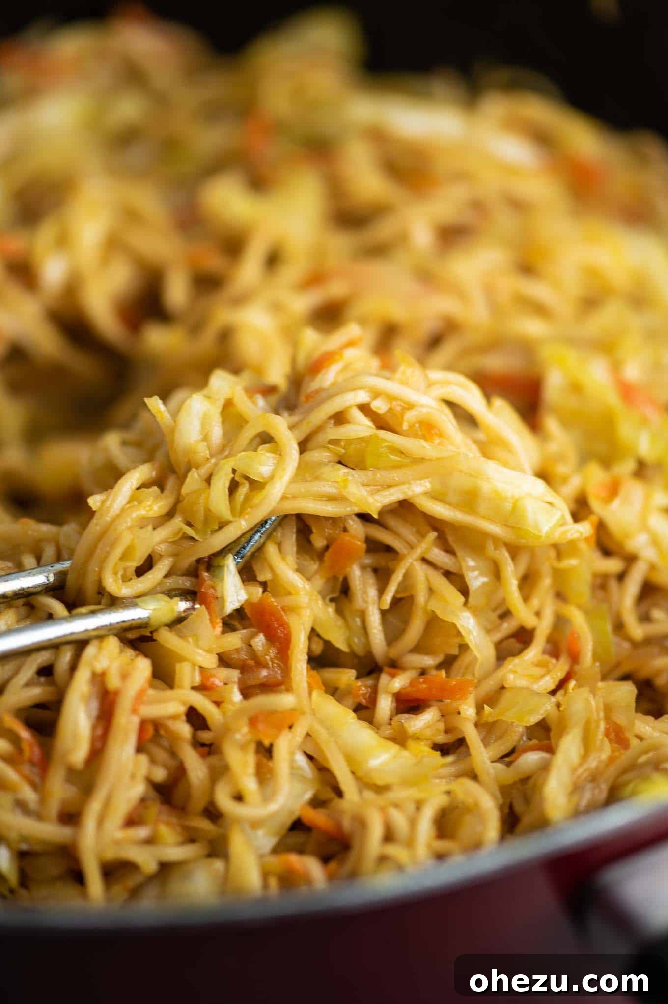 Vibrant cabbage and carrots cooking in a red pan, ready to be transformed into a delicious stir fry.