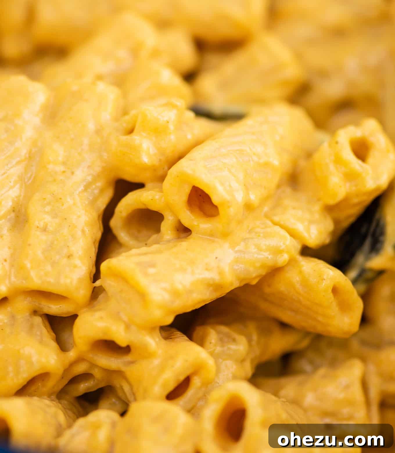 up close rigatoni with dripping pumpkin pasta sauce