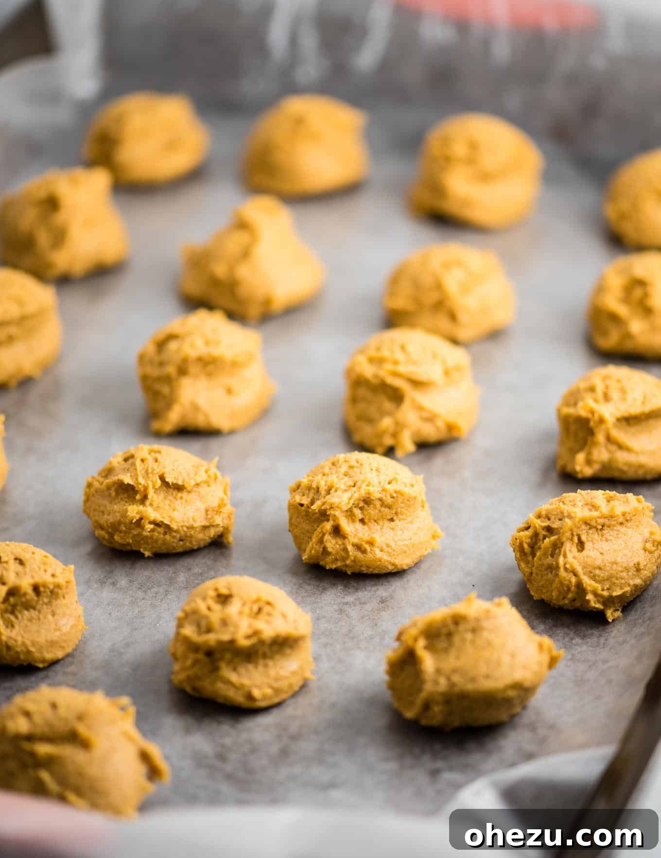 Pumpkin truffle filling in small balls on a baking sheet, ready for chilling