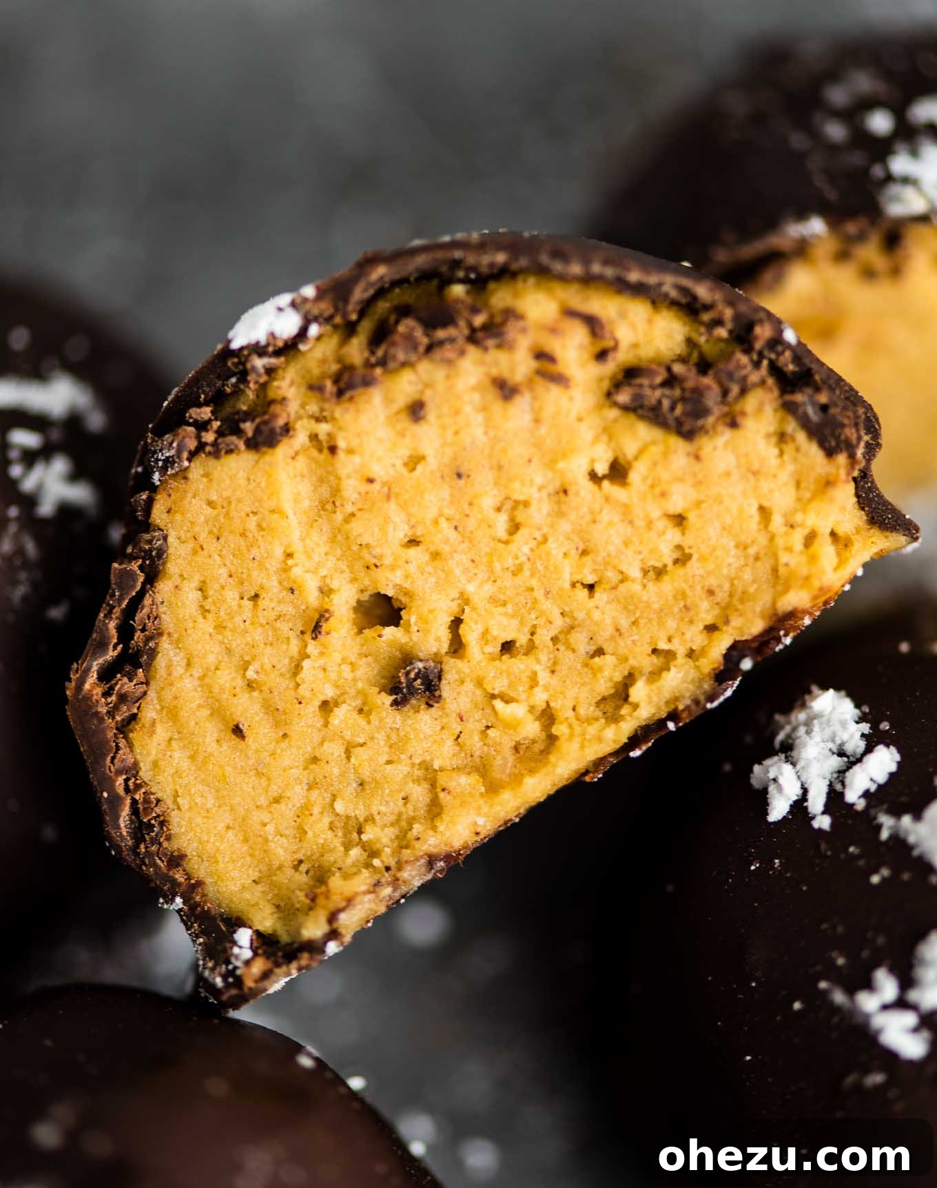 Pumpkin truffles with dark chocolate cut open, revealing creamy texture