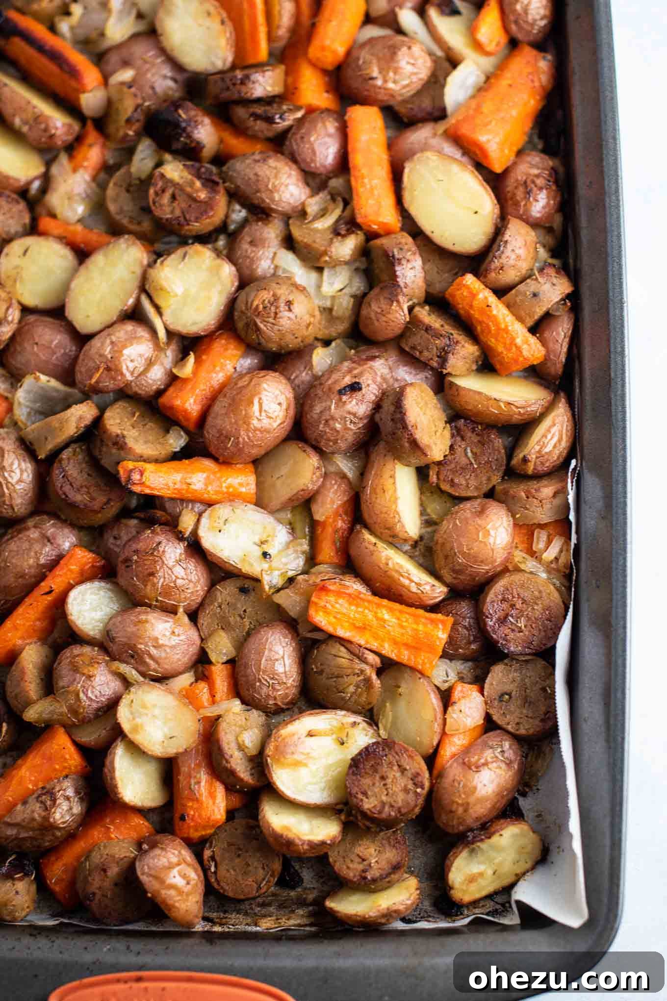 Vegetarian kielbasa and roasted vegetables from an overhead view, beautifully arranged on a white plate, ready to serve.