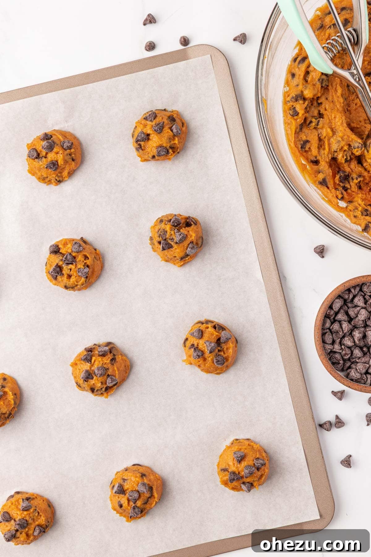 Harvest Pumpkin Chocolate Chip Cookies 13 Pumpkin chocolate chip cookie dough balls on a baking sheet, ready for the oven