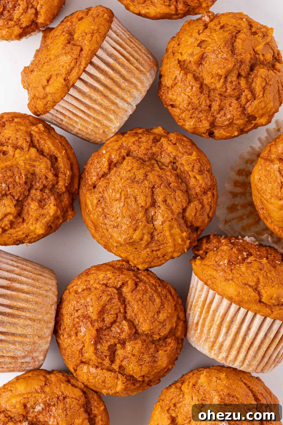 Close-up of three cake mix pumpkin muffins stacked, showcasing their beautiful tops and soft texture