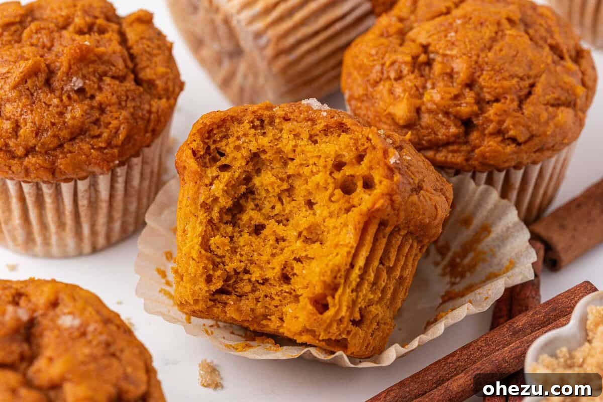 A single cake mix pumpkin muffin with a bite taken out, resting on a white surface, showcasing its appeal