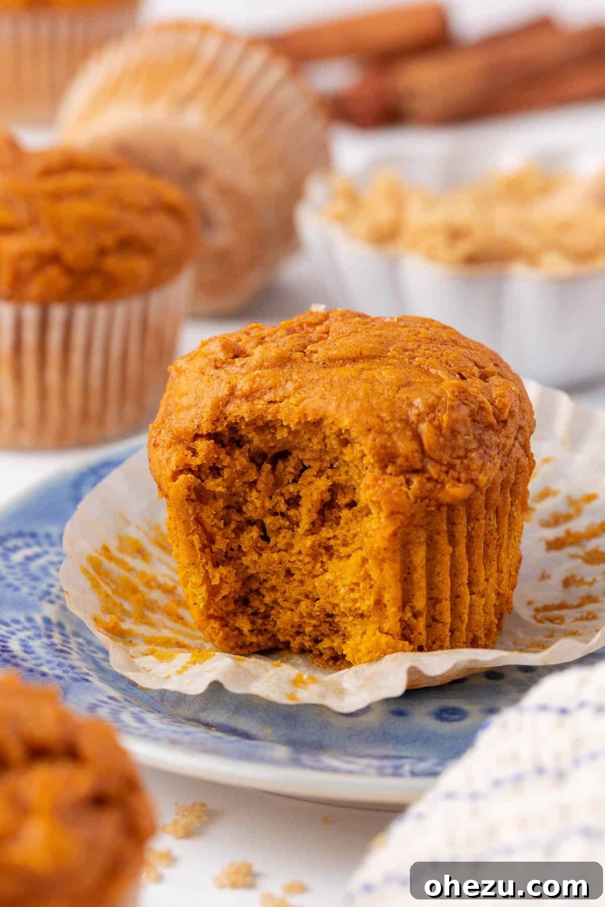 Close-up of a perfectly baked cake mix pumpkin muffin with a bite taken out, showing its moist interior