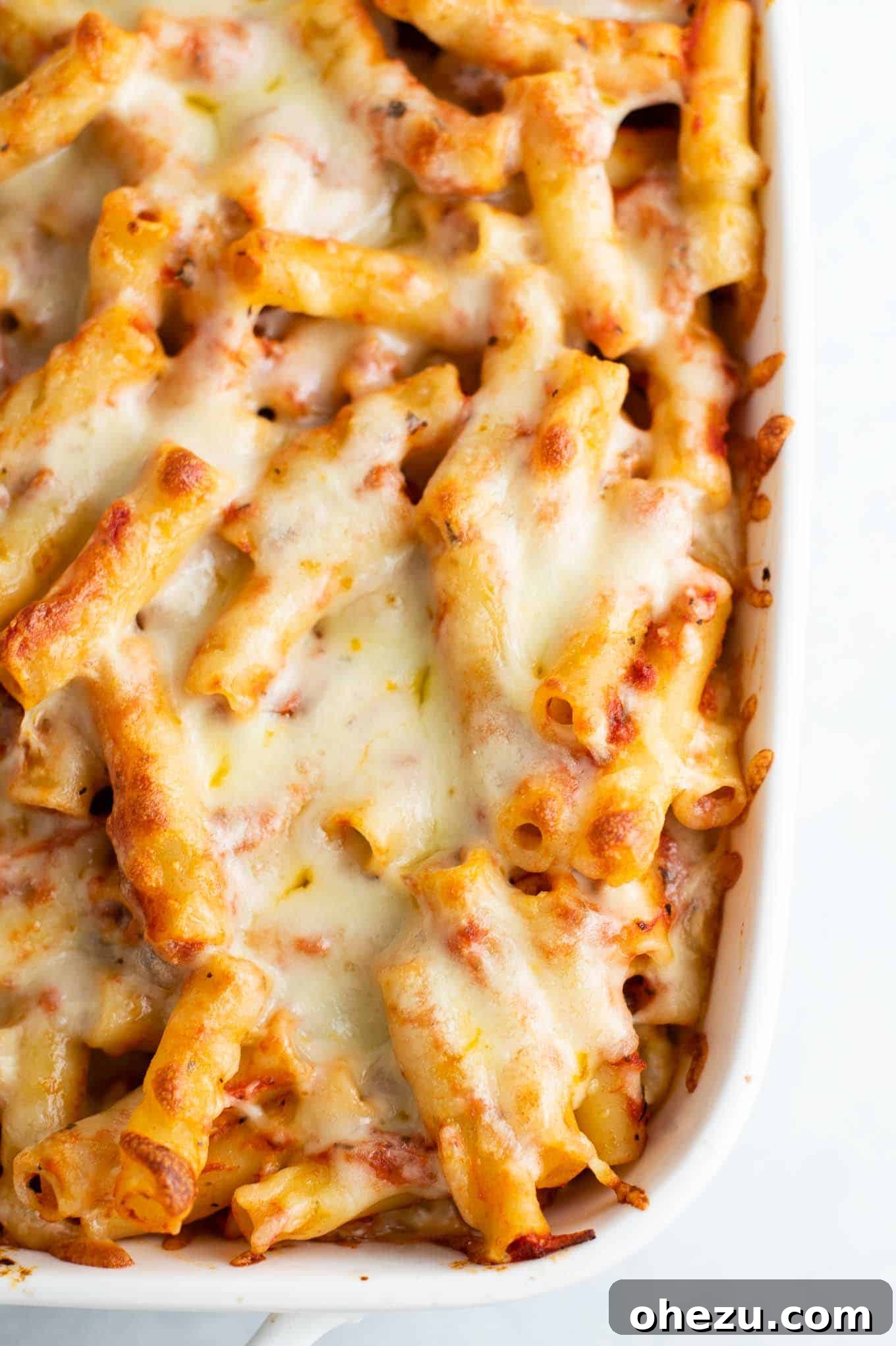baked ziti with melted cheese on top, golden brown and bubbly