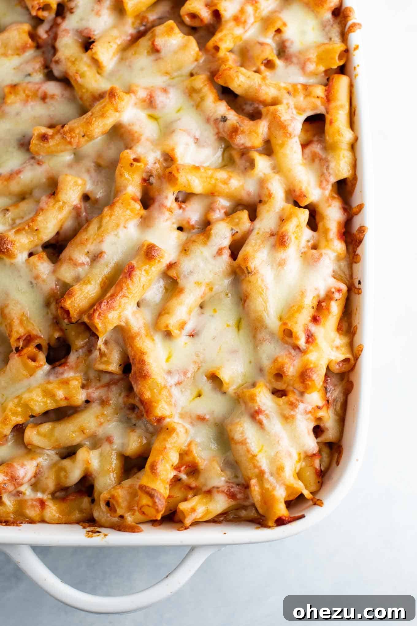 overhead shot of the baked ziti in the casserole dish before baking, with mozzarella cheese on top