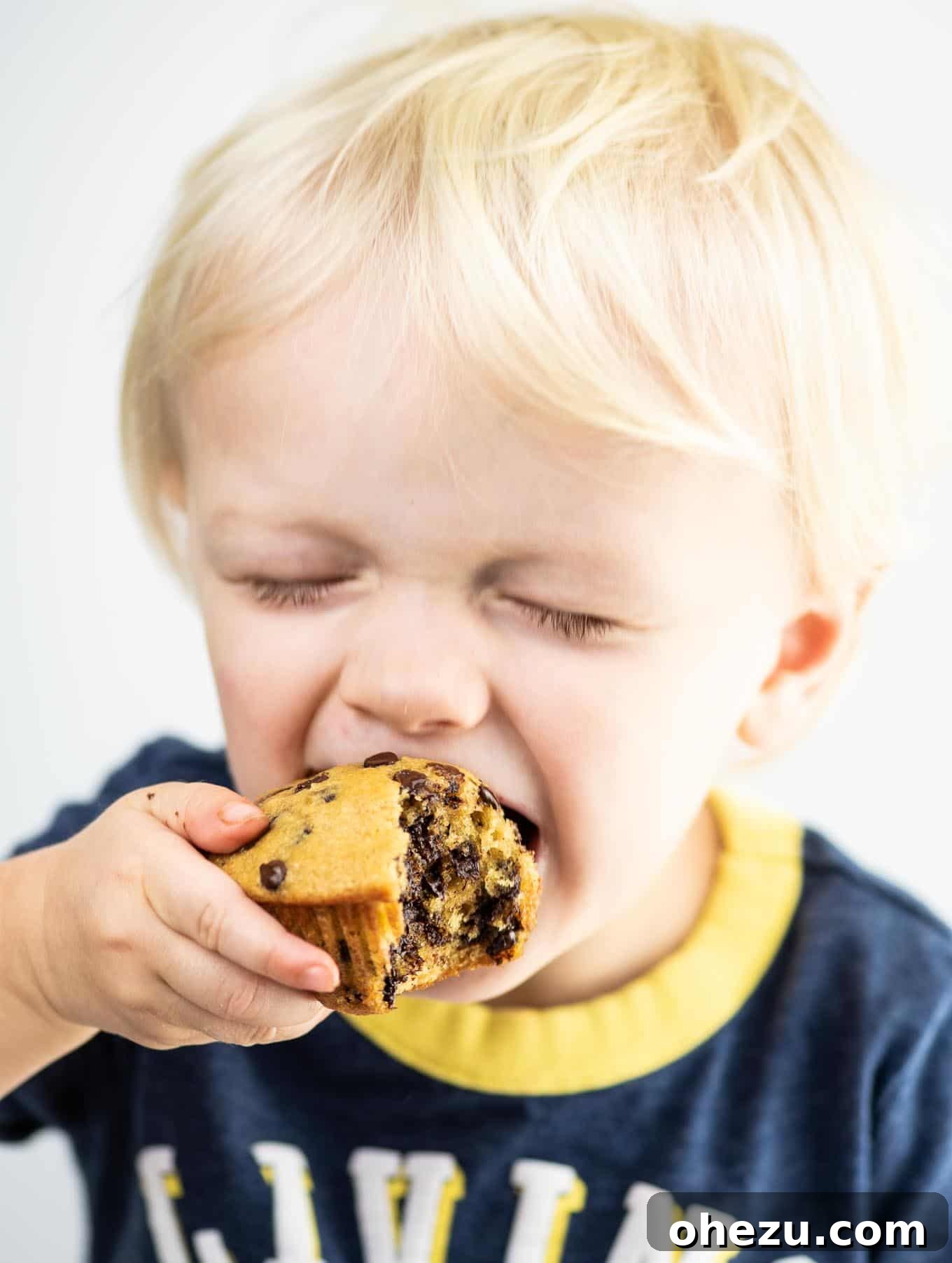 My Five-Year Food Blogging Journey 7 toddler taking a bite of a chocolate chip muffin