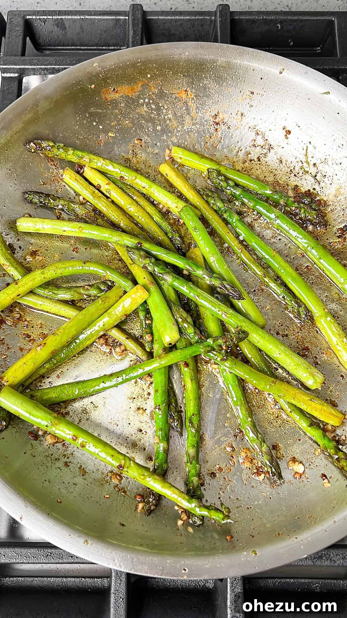 Perfectly cooked asparagus in a pan, lightly browned and tender.
