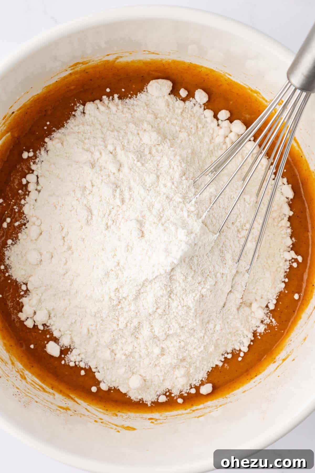 Adding yellow cake mix to the wet pumpkin mixture.