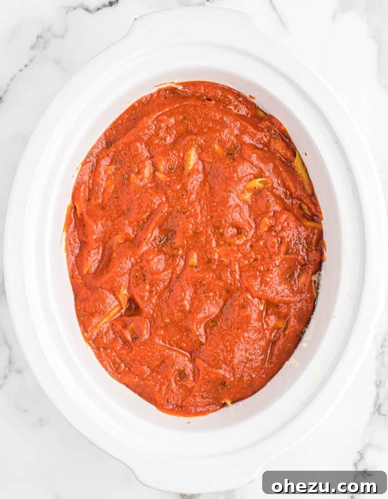Effortless Slow Cooker Baked Ziti 16 The remaining rich pasta sauce poured generously over the top of the crock pot baked ziti, ensuring full coverage.