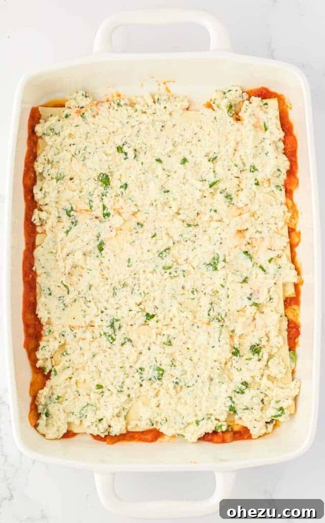 Triple Cheese Lasagna 12 Creamy ricotta cheese filling spread evenly over the first layer of lasagna noodles.