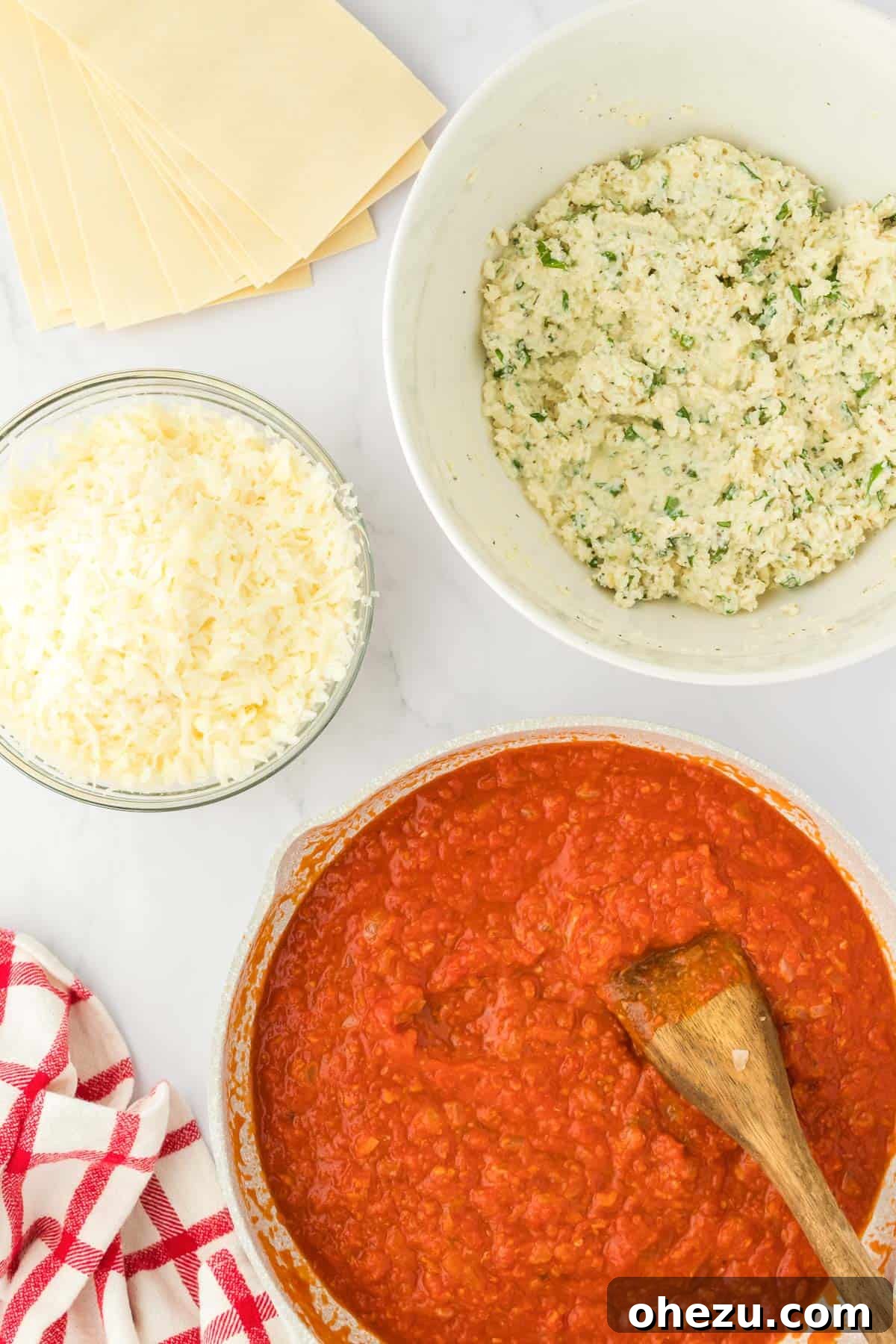 Triple Cheese Lasagna 4 Individual ingredients for assembling cheese lasagna, including a bowl of ricotta, a container of pasta sauce, and shredded mozzarella.