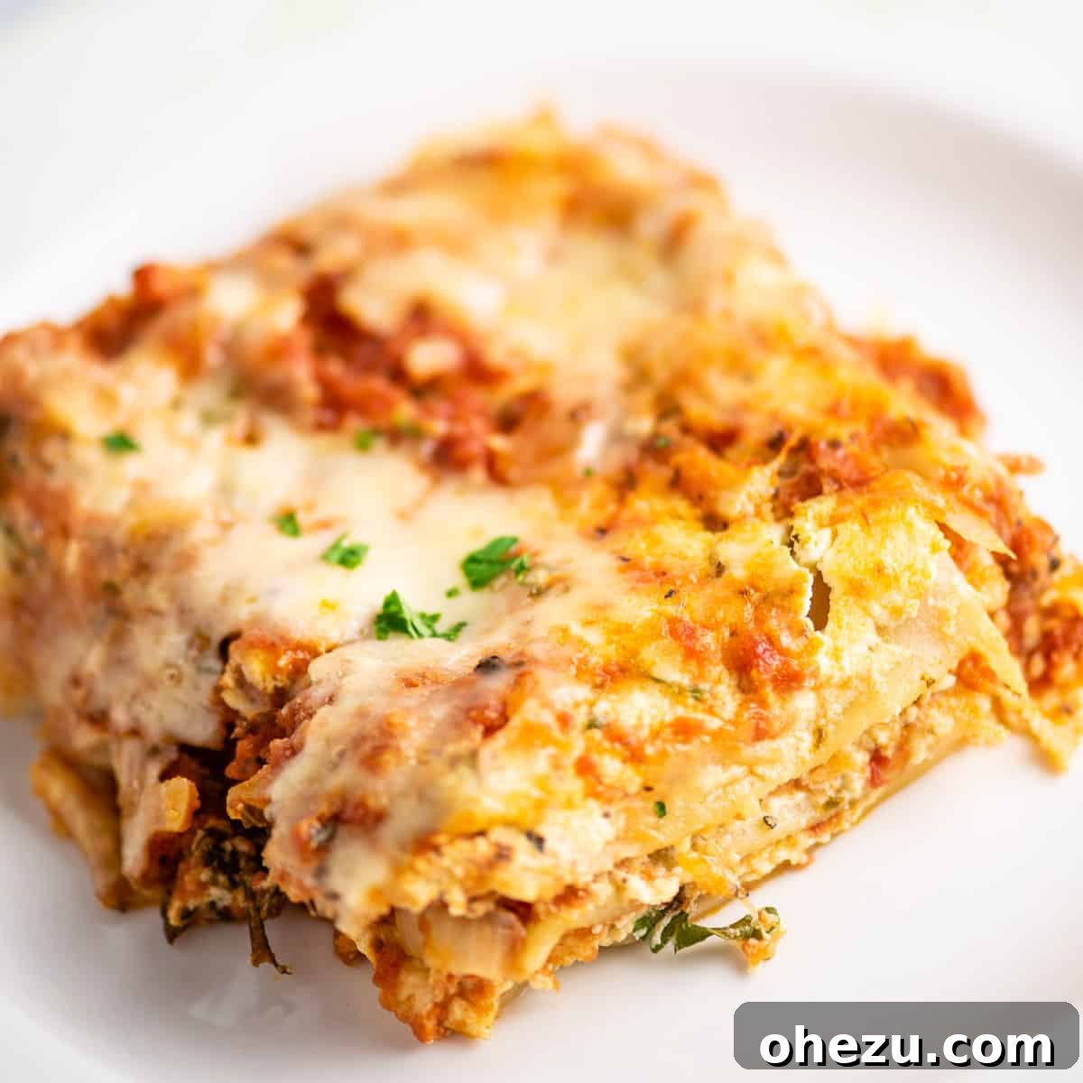 Triple Cheese Lasagna 31 A close-up shot of a single slice of three cheese lasagna, revealing its perfectly cooked layers and rich texture.