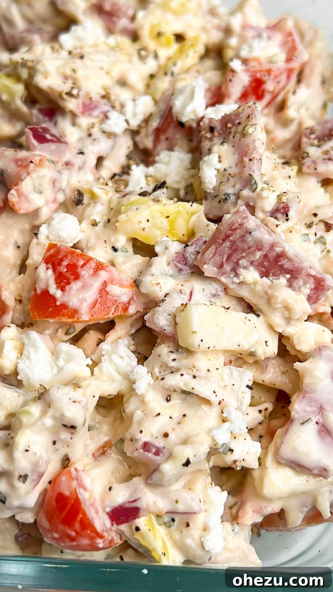 A large bowl filled with freshly prepared Italian Grinder Chicken Salad, showing the mix of chicken, deli meats, vegetables, and creamy dressing.