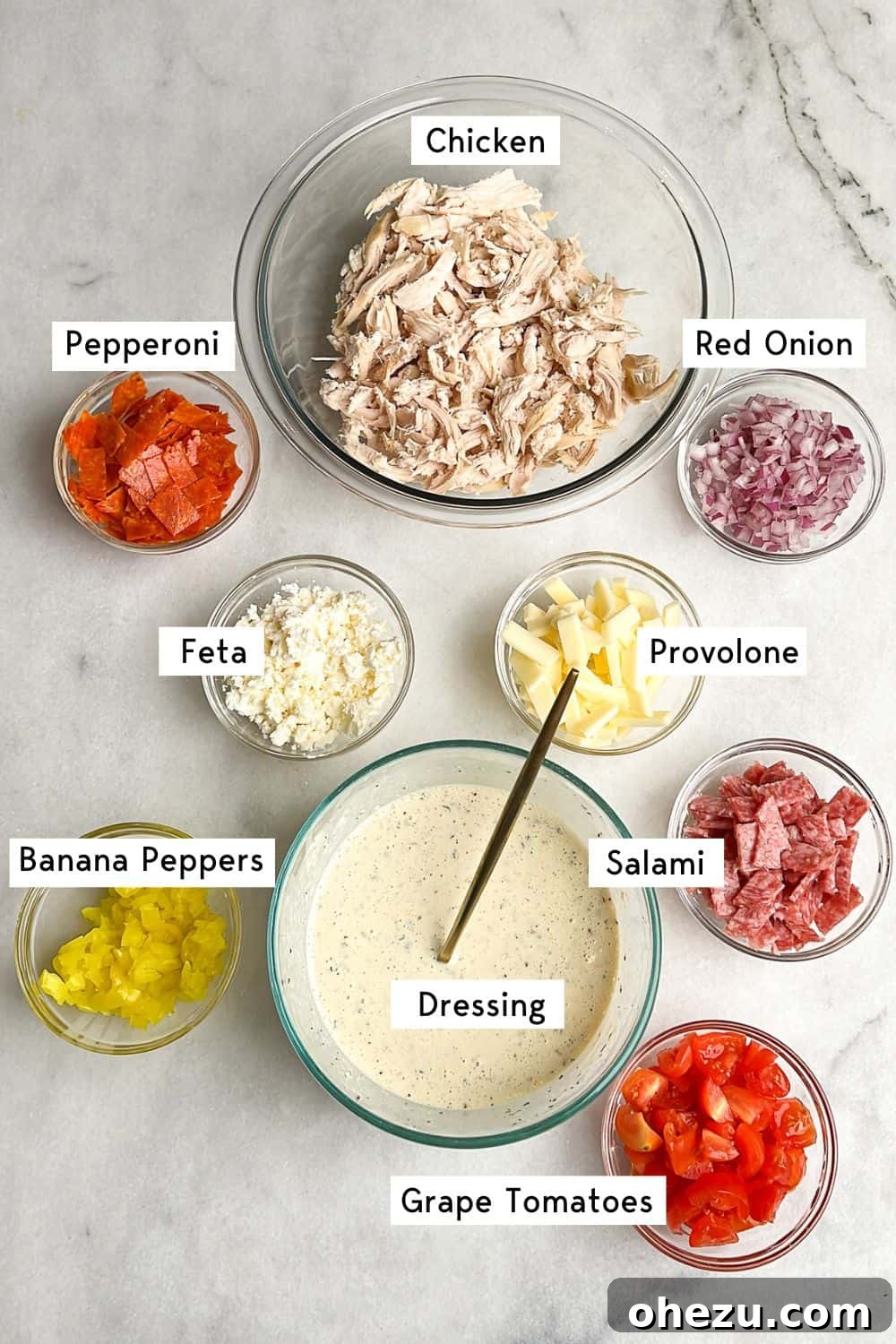 All the prepped ingredients for the Italian Grinder Chicken Salad neatly arranged in separate bowls, ready for mixing.
