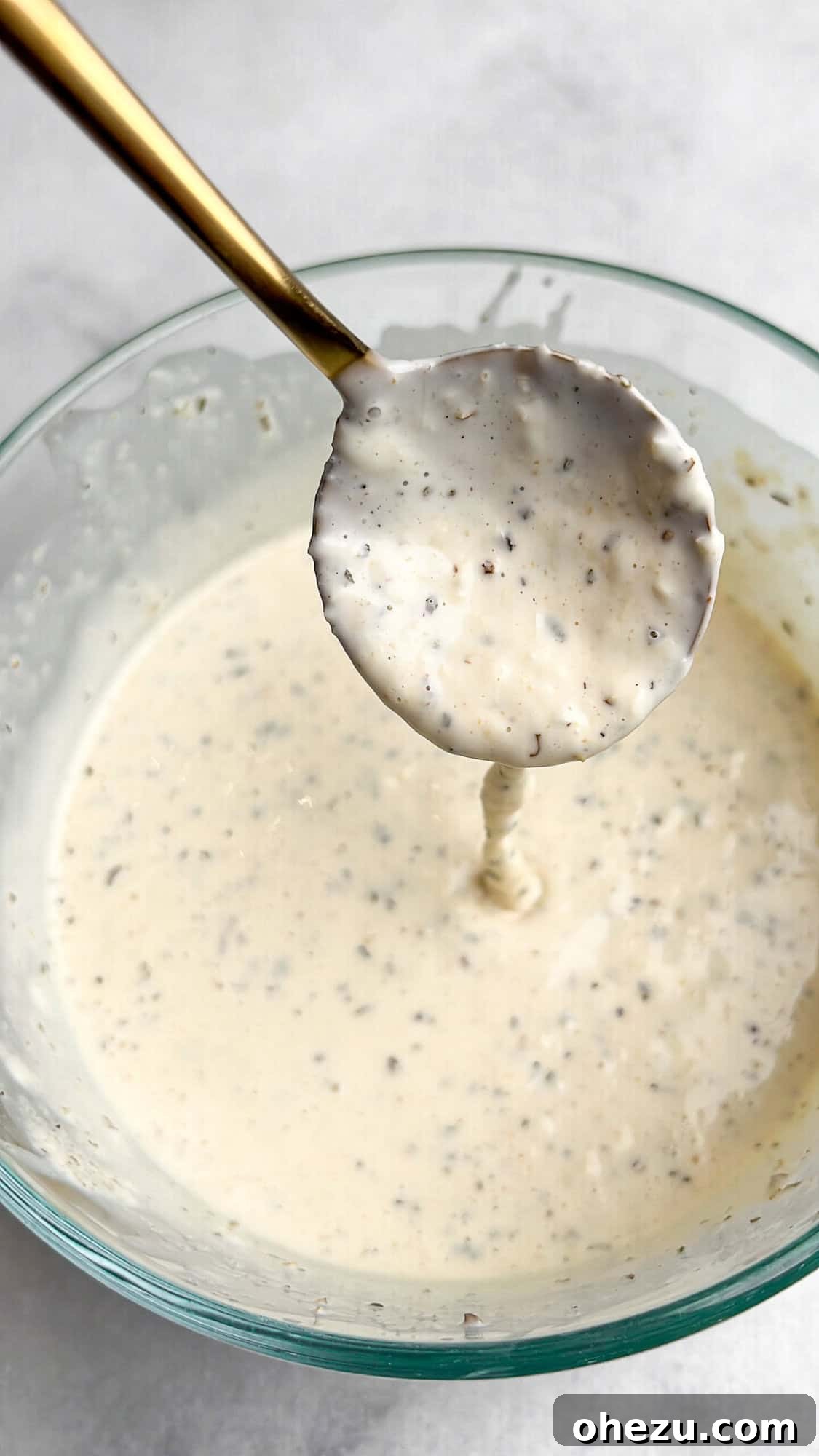 Close-up of the Italian Grinder Salad dressing being mixed in a bowl, showcasing its creamy texture.