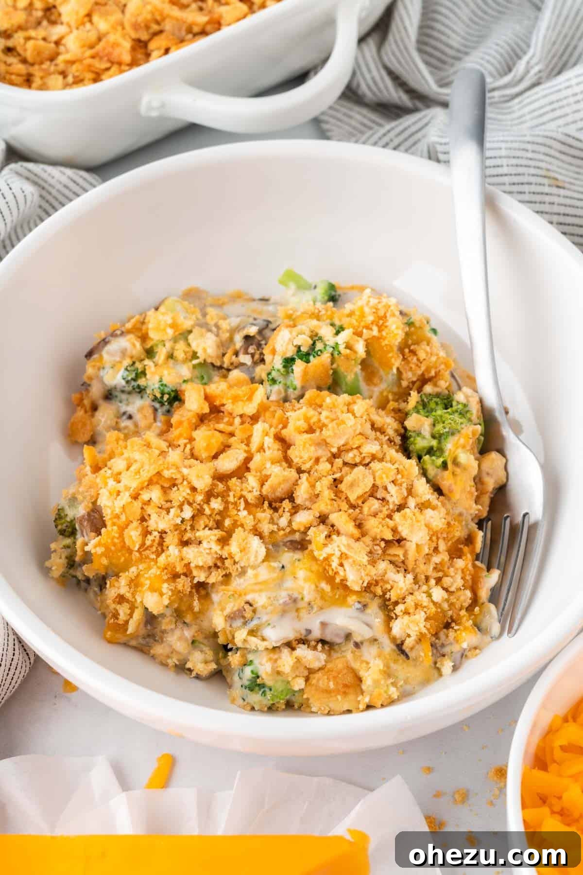 Broccoli casserole in a white serving bowl, topped with golden Ritz crackers, ready to be enjoyed