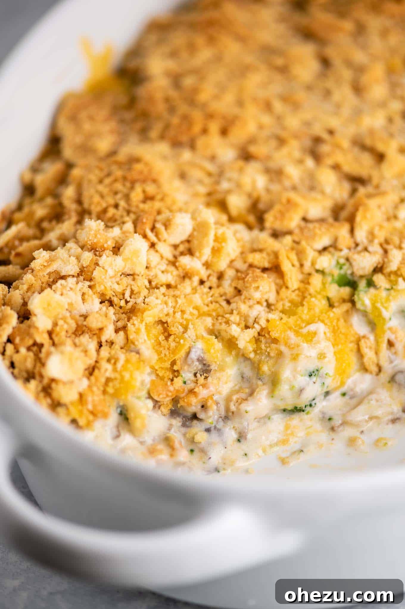 Ritz cracker topped casserole with a scoop taken out, showing the creamy interior and golden crust