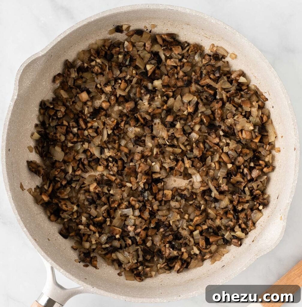 Sautéed mushrooms, garlic, and onion in a skillet, softened and fragrant