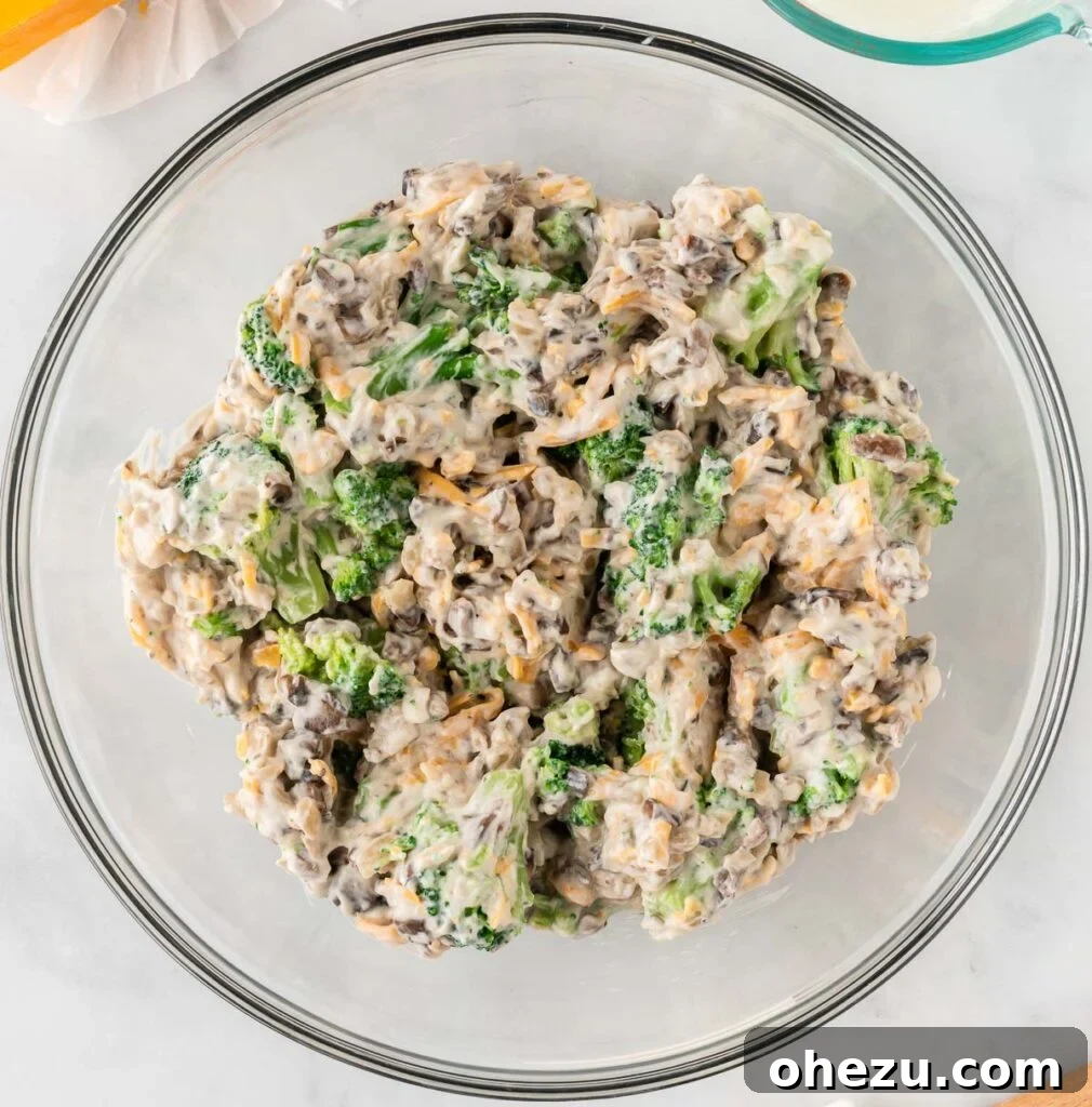 Broccoli casserole ingredients mixed together in a bowl, creamy and vibrant