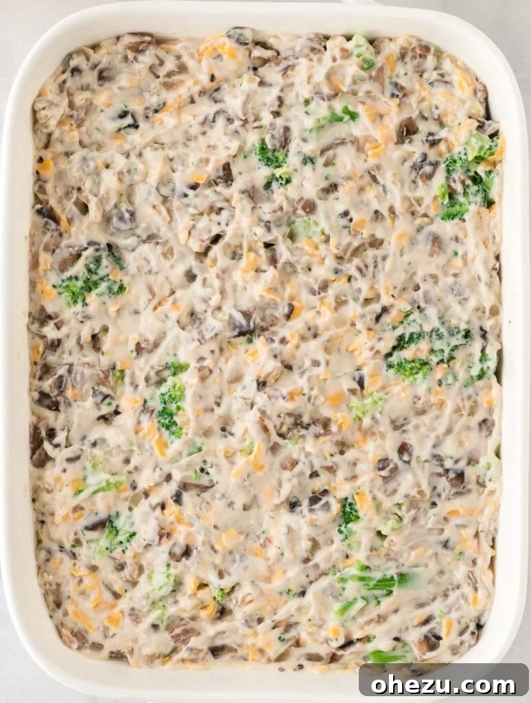 Broccoli casserole filling spread out evenly in a baking dish