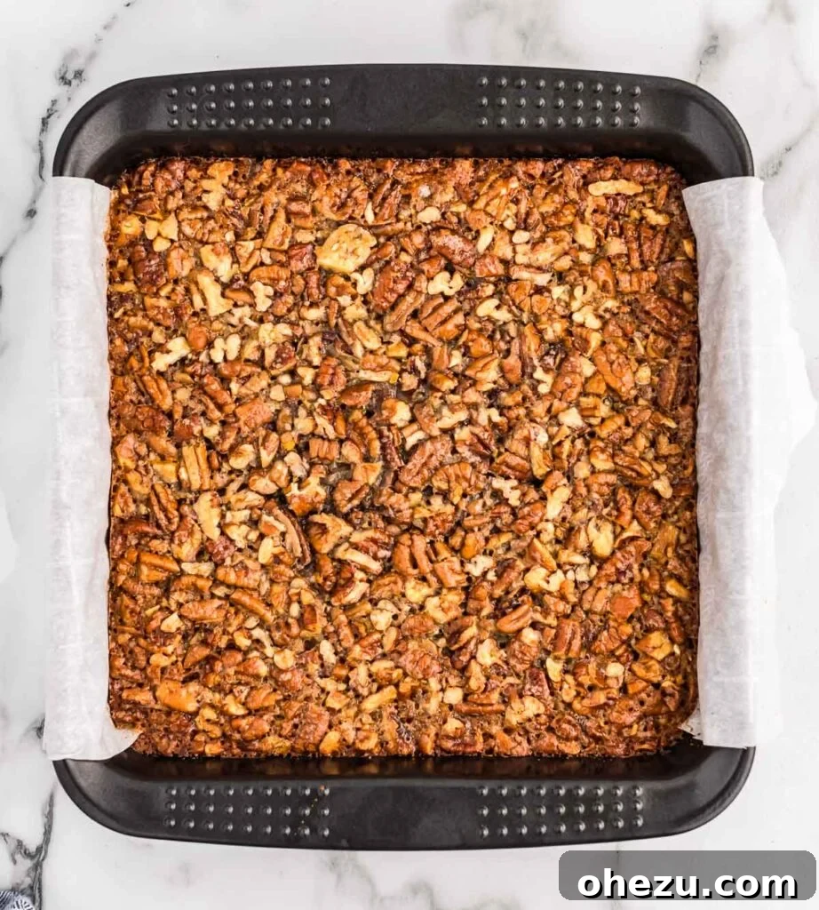 pecan pie bar filling poured over shortbread crust
