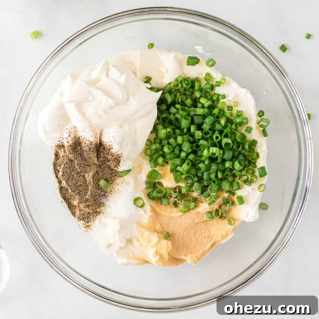 The Ultimate Cheese Ball 5 cream cheese, sour cream, green onions, and spices in a bowl