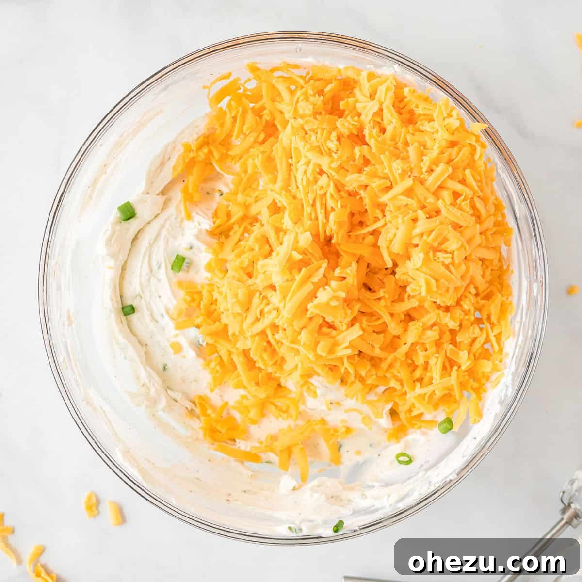 The Ultimate Cheese Ball 8 shredded cheddar added to the cheese ball ingredients