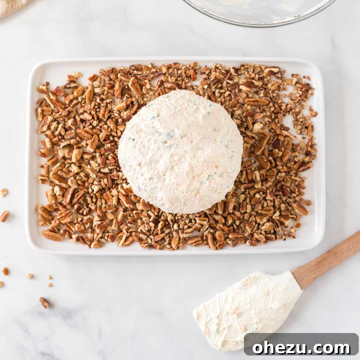 The Ultimate Cheese Ball 9 cheese ball on a plate of pecan pieces