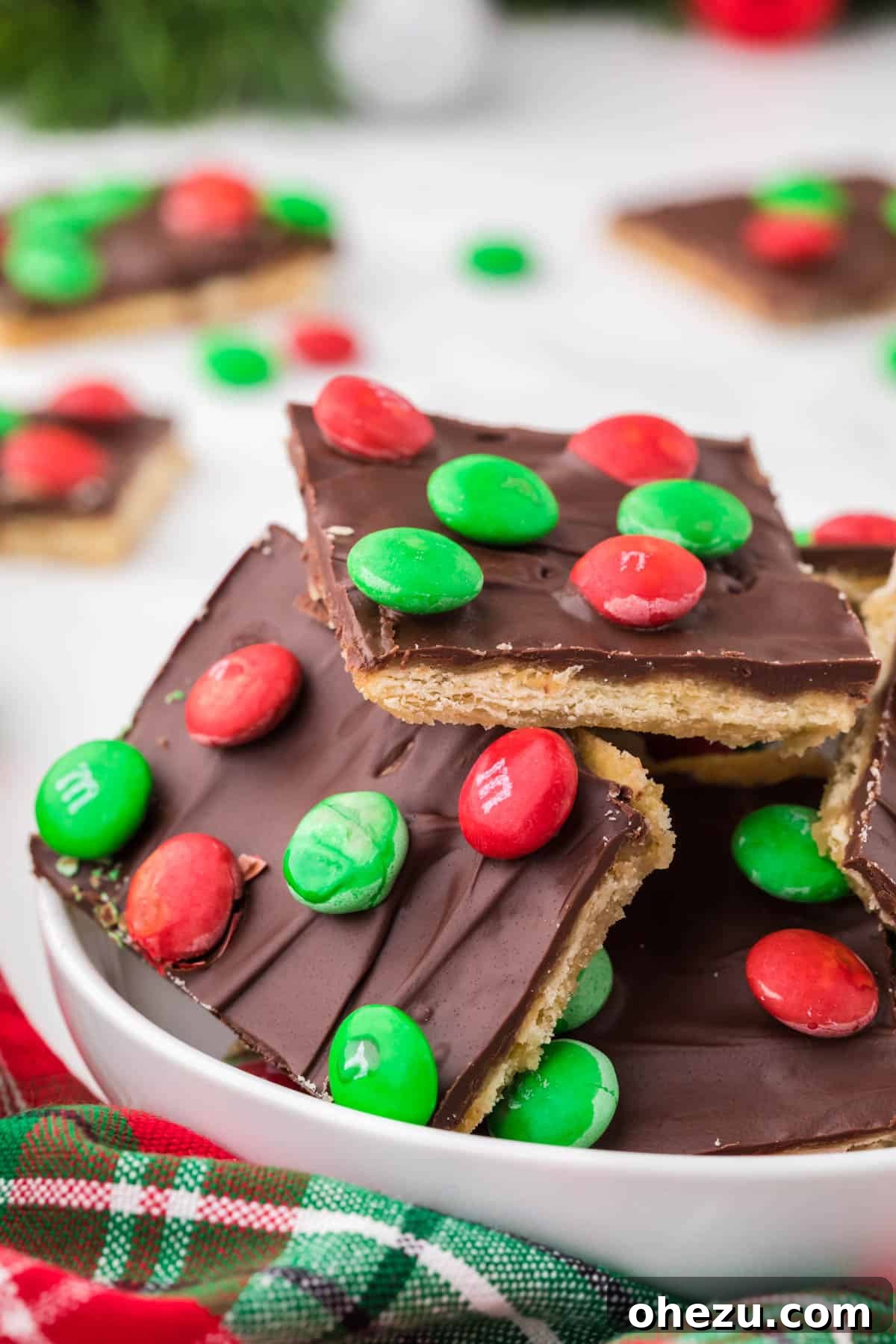Irresistible Christmas Toffee Bark 2 Delicious pieces of Christmas Crack (Saltine Cracker Toffee Candy) in a festive bowl, ready to be enjoyed.