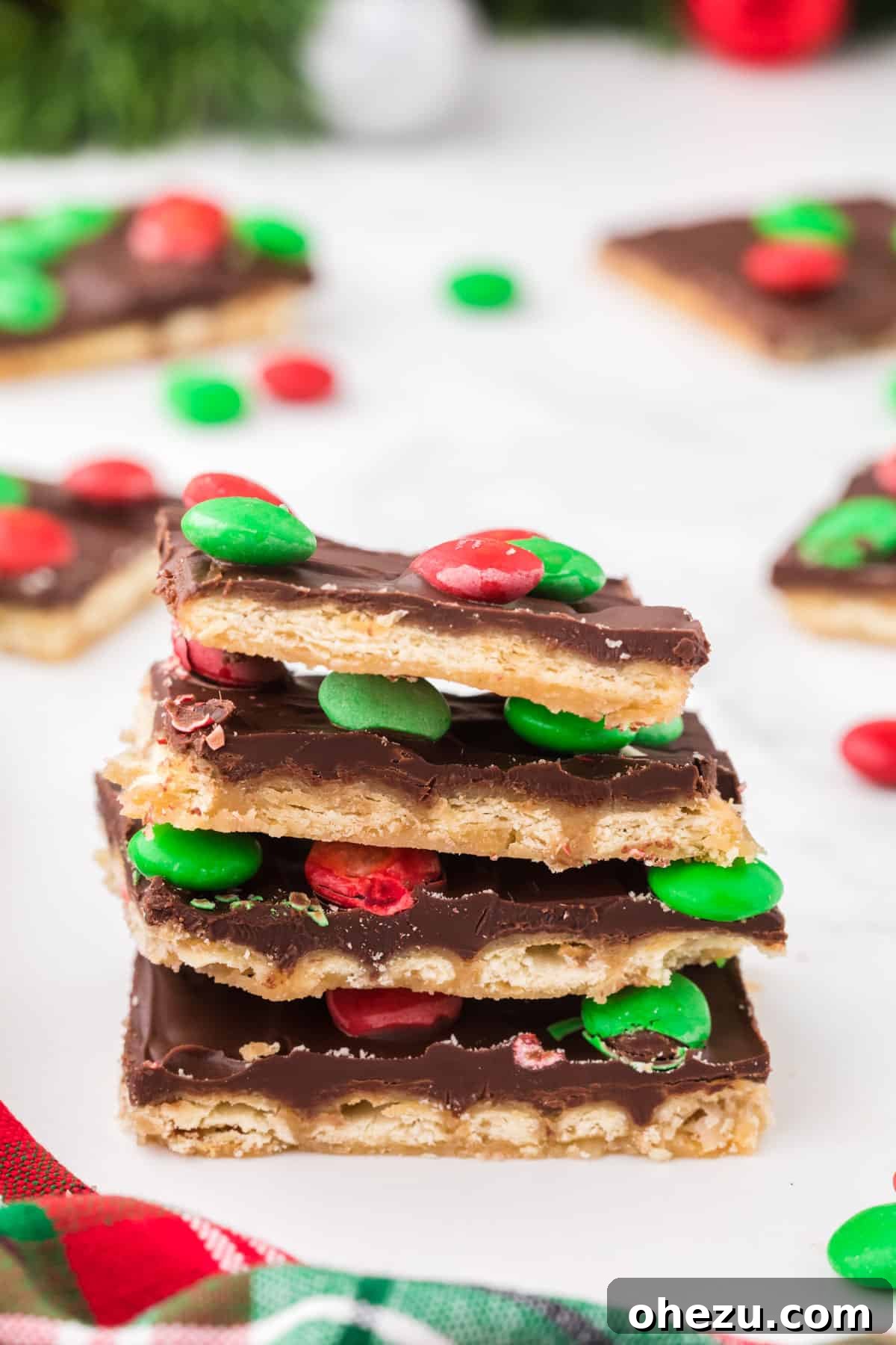 Irresistible Christmas Toffee Bark 17 Close-up of individual Christmas Crack pieces decorated with colorful holiday M&M's, perfect for a festive gathering.